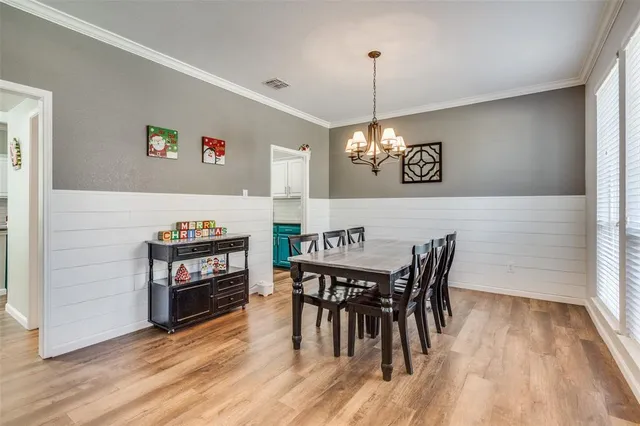 a view of a dining room with furniture wooden floor and chandelier