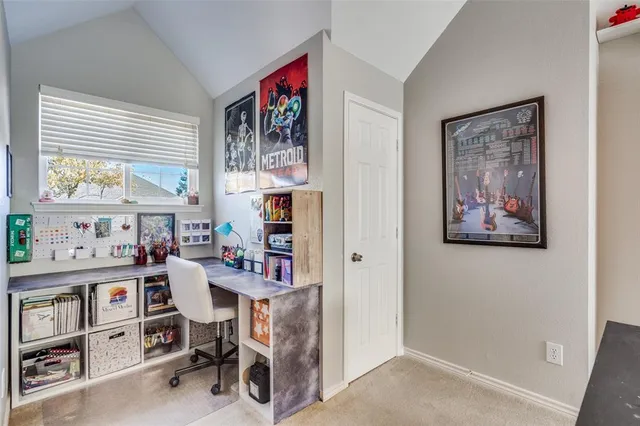 a view of a workspace with furniture and a window