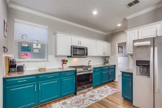 a kitchen with stainless steel appliances granite countertop a refrigerator and a stove top oven