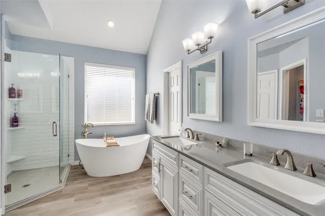 a spacious bathroom with a double vanity sink mirror and bathtub