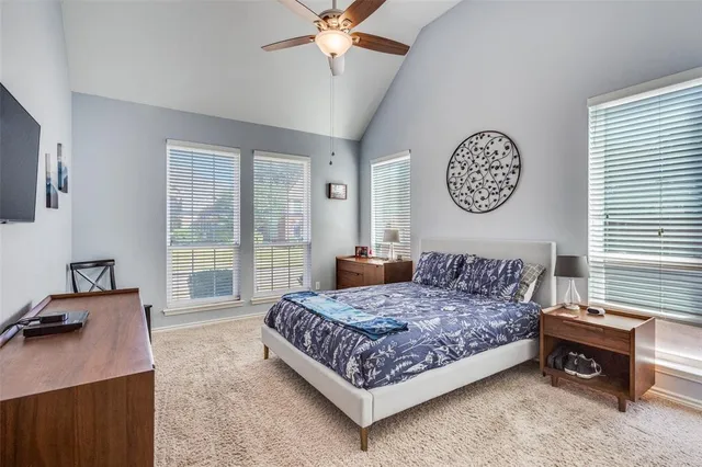 a bedroom with a bed and a table in it with window