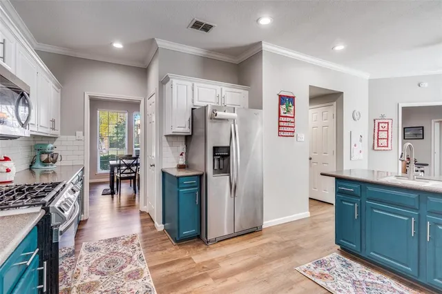 a kitchen with stainless steel appliances granite countertop a refrigerator and a stove top oven