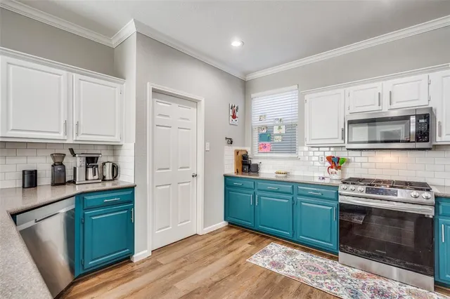 a kitchen with stainless steel appliances granite countertop a stove a sink and a microwave