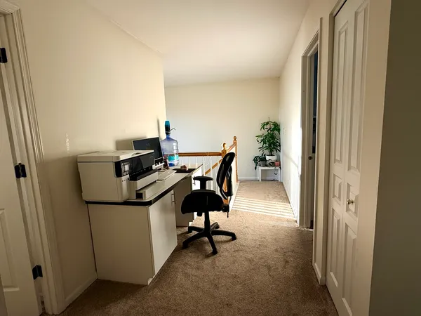 a view of a workspace with furniture and a window