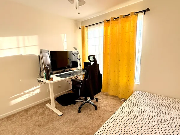 a view of a workspace with furniture and a window