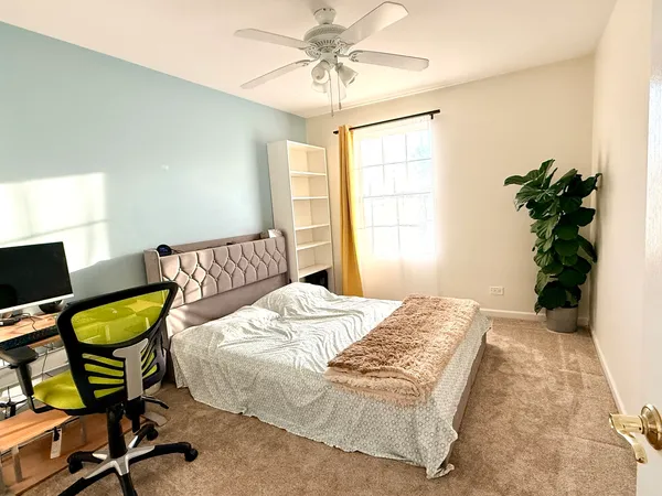 a bedroom with a bed and a potted plant