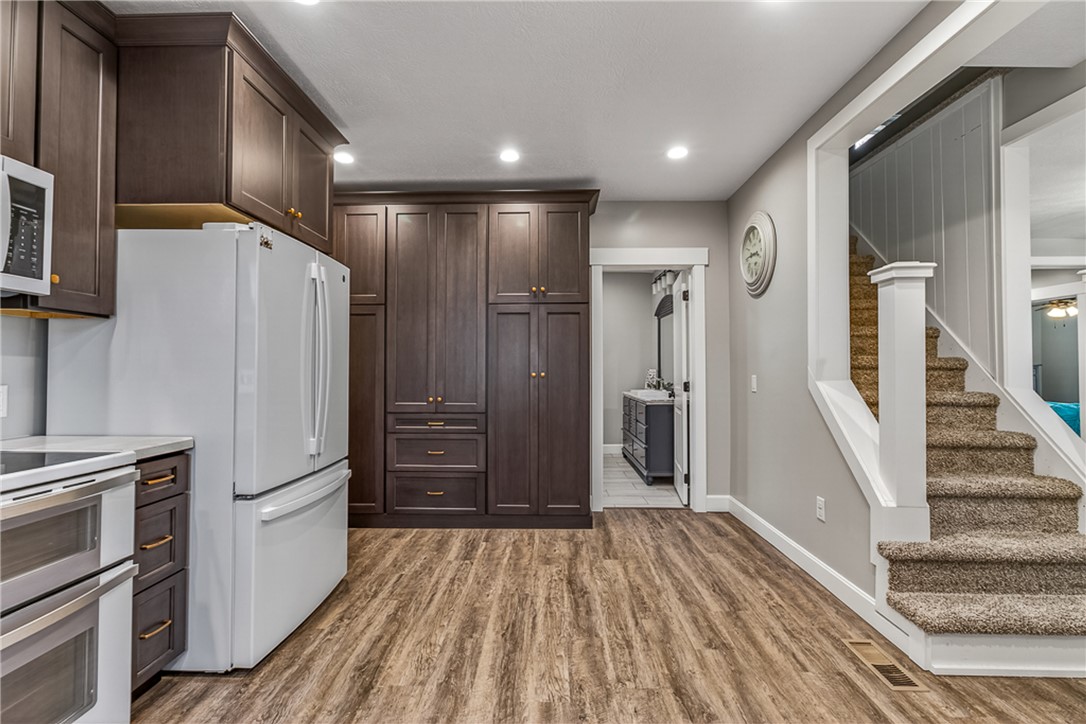 8700 Quaker Trace Road Camden, OH 45311 - Photo 9 of 34 This kitchen showcases ample cabinetry and modern appliances, with convenient access to a secondary space and staircase.