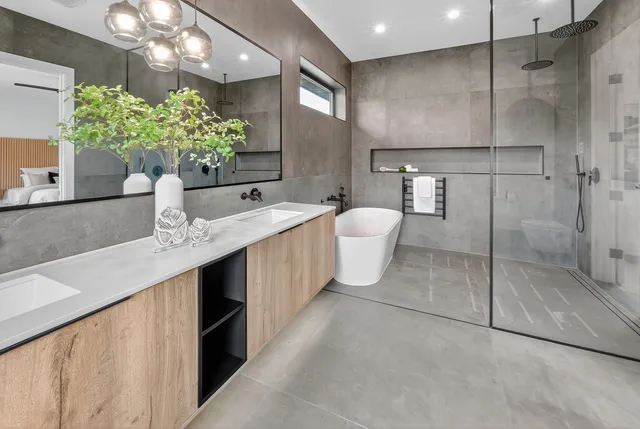 a bathroom with a granite countertop sink a toilet a mirror and shower