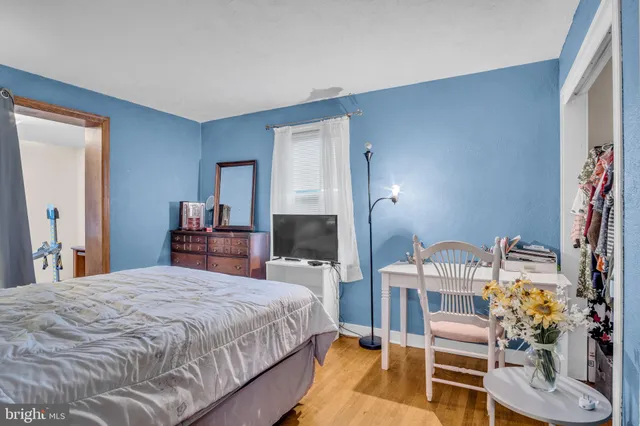 a bedroom with a bed and a flat tv screen on dresser