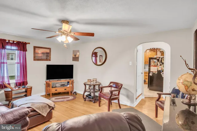 a living room with furniture a flat screen tv and a window