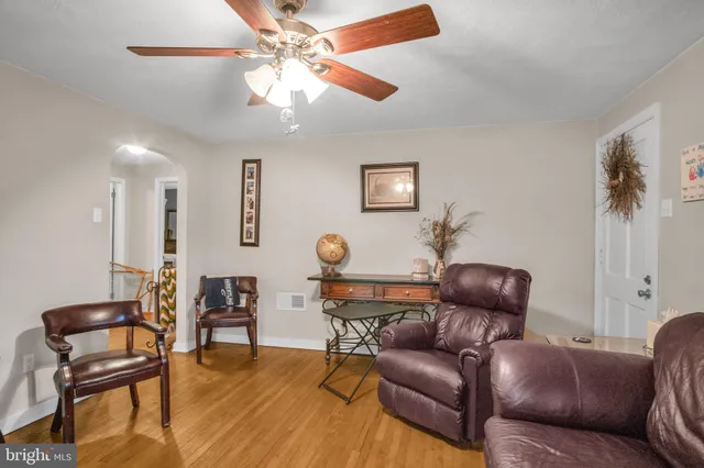 a living room with furniture a ceiling fan and a rug