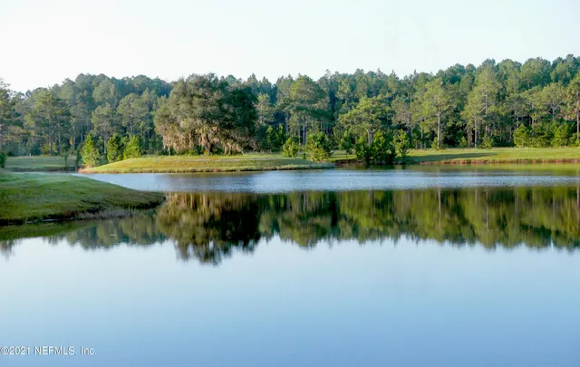 a view of a lake with a yard and outdoor seating