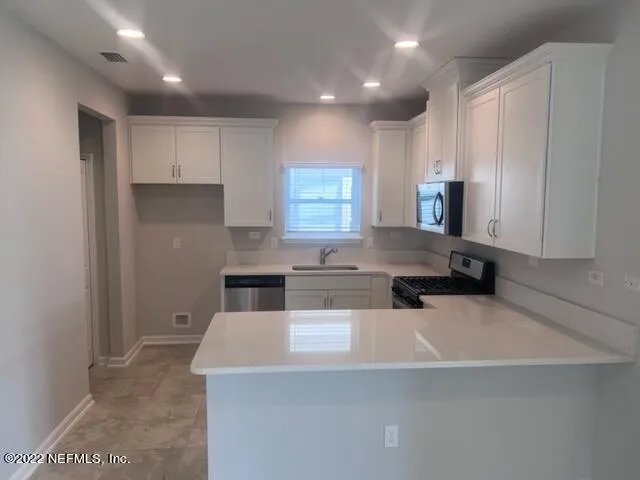 a kitchen with kitchen island a stove a sink and a refrigerator
