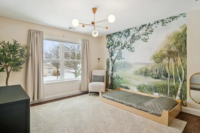 a spacious bedroom with a large bed and a chandelier