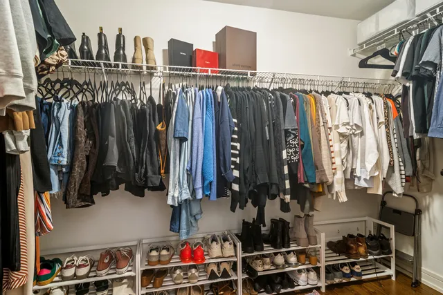 a view of walk in closet with clothes and shoes