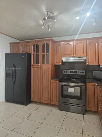a kitchen with granite countertop a stove and cabinets