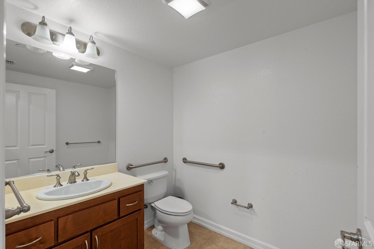 1353 El Camino Real Millbrae, CA 94030 - Photo 11 of 25 a bathroom with a toilet a sink and mirror