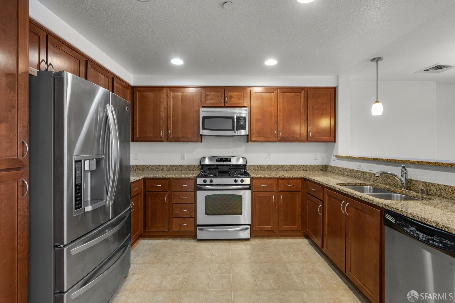 1353 El Camino Real Millbrae, CA 94030 - Photo 8 of 25 a kitchen with granite countertop stainless steel appliances and wooden cabinets
