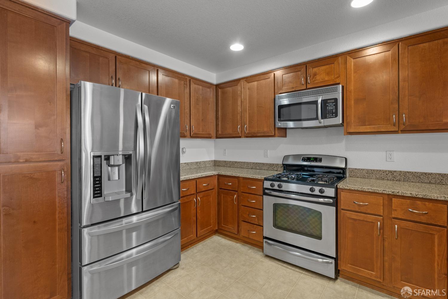 1353 El Camino Real Millbrae, CA 94030 - Photo 9 of 25 a kitchen with stainless steel appliances granite countertop a stove microwave and refrigerator
