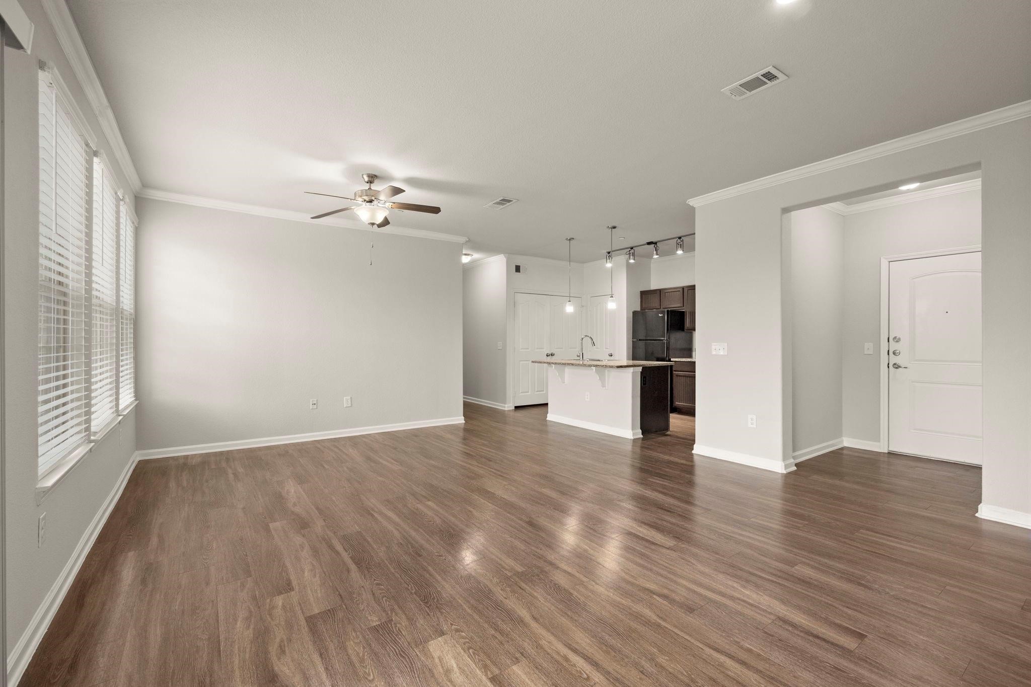 30685 Fm 2978 Road, Unit 4002 Magnolia, TX 77354 - Photo 6 of 16 a view of an empty room with a kitchen and wooden floor