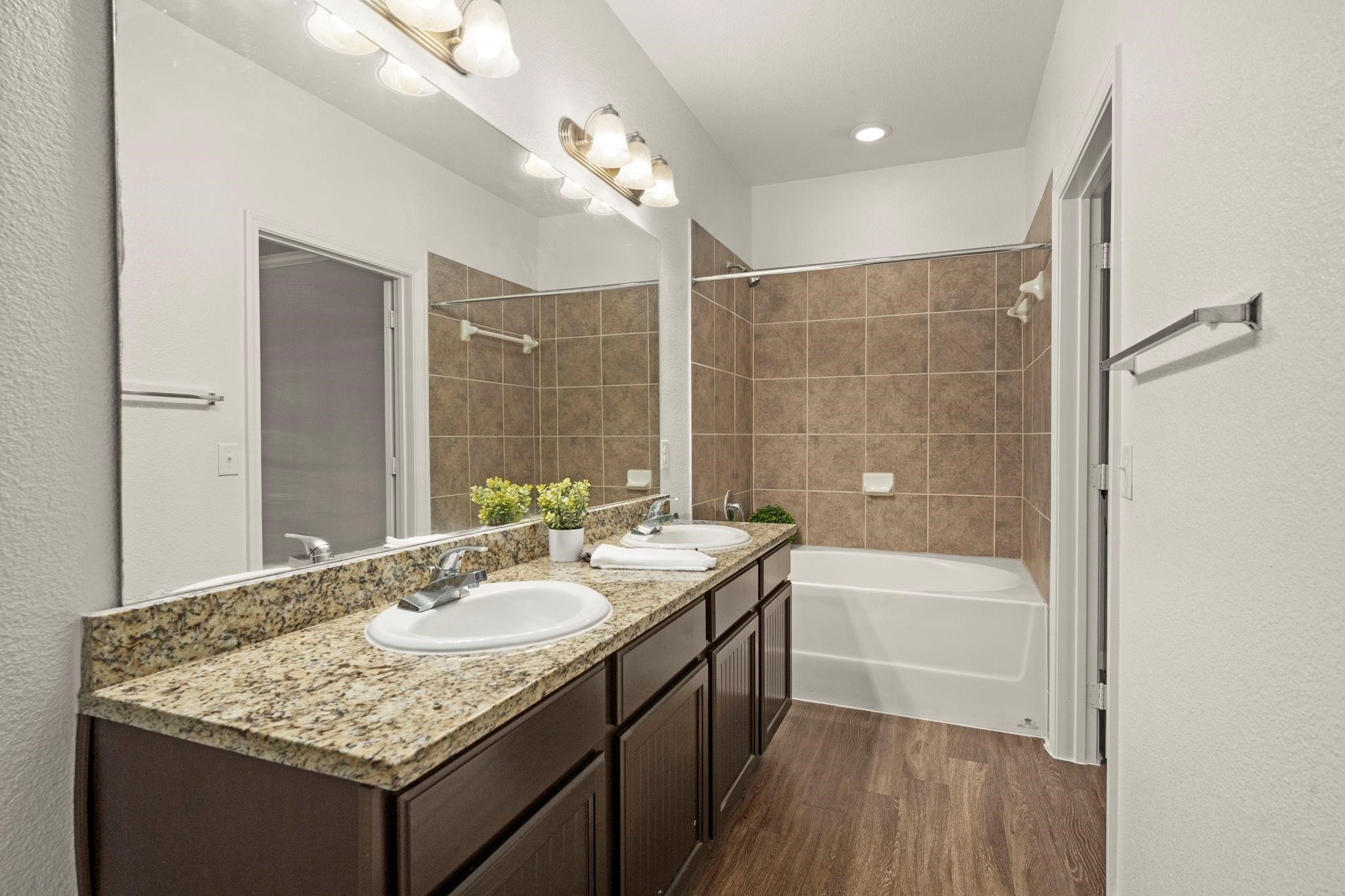 30685 Fm 2978 Road, Unit 4002 Magnolia, TX 77354 - Photo 8 of 16 a bathroom with a granite countertop sink a toilet a mirror and bathtub