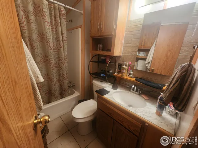 a bathroom with a sink a toilet a mirror and shower curtain
