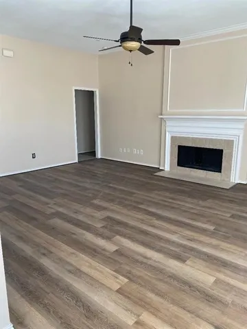 a view of empty room with wooden floor and fireplace