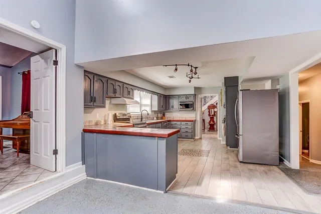 a kitchen with stainless steel appliances granite countertop a refrigerator and a sink