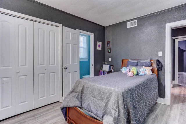 a bedroom with a bed and wooden floor