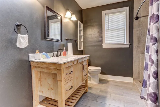 a bathroom with a sink toilet and mirror