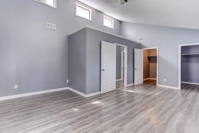 a view of an empty room with wooden floor
