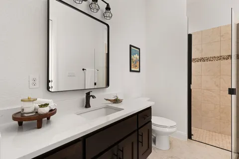 a bathroom with a sink a toilet and mirror