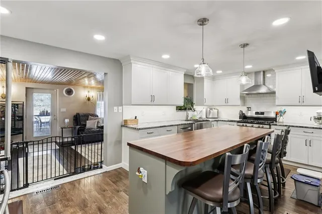 a kitchen with kitchen island a dining table chairs and white cabinets