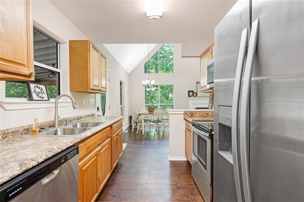 129 Jump Street Talking Rock, GA 30175 - Photo 11 of 45 a kitchen with stainless steel appliances granite countertop a refrigerator a sink dishwasher a stove and white countertops with wooden floor