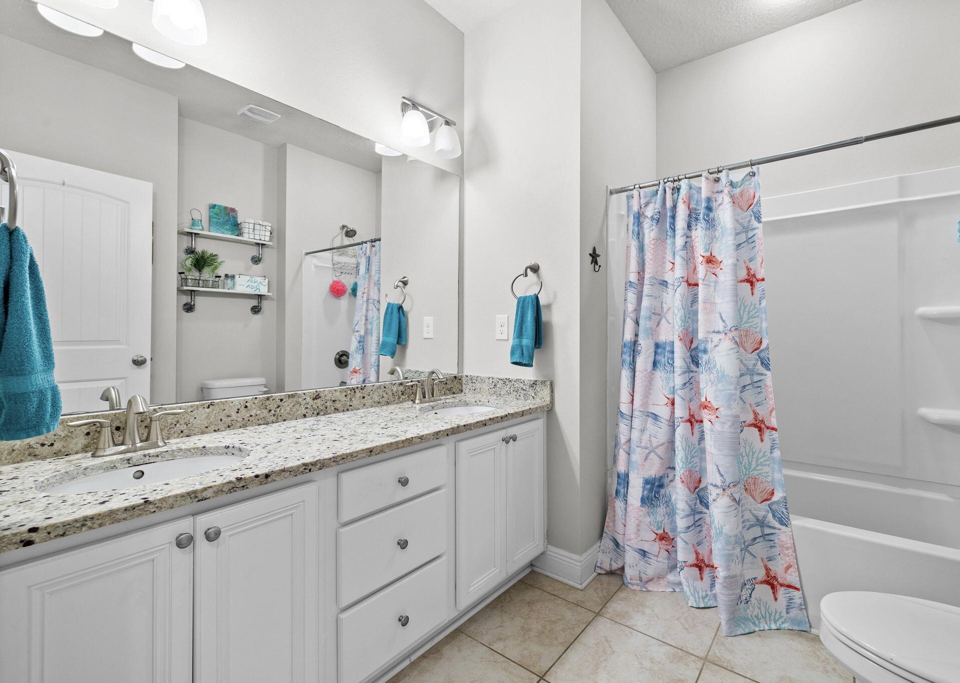 672 Alderberry Road Santa Rosa Beach, FL 32459 - Photo 15 of 24 a bathroom with a granite countertop sink a toilet and shower
