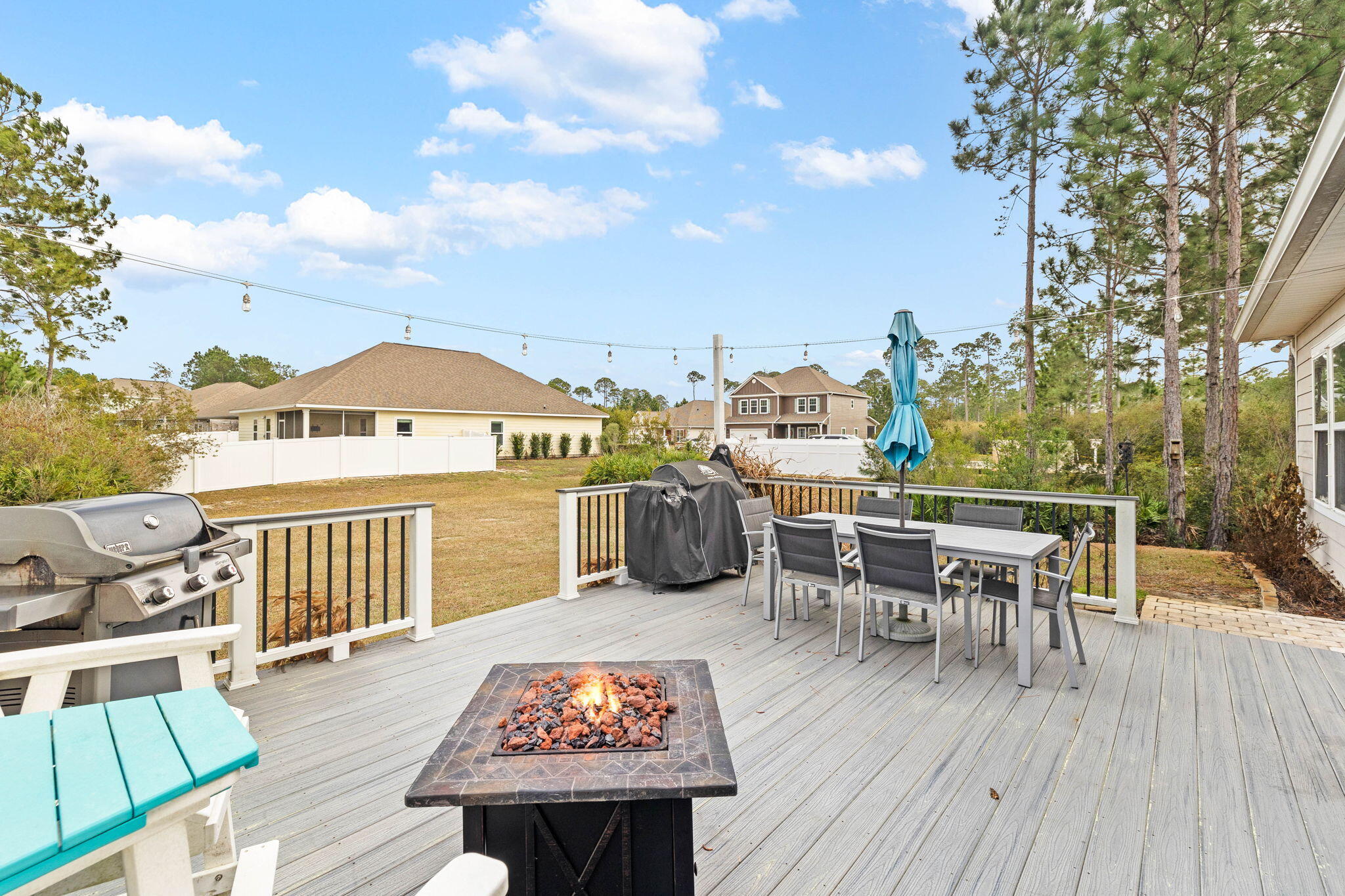 672 Alderberry Road Santa Rosa Beach, FL 32459 - Photo 19 of 24 a view of a roof deck with table and chairs couches with wooden floor and fence