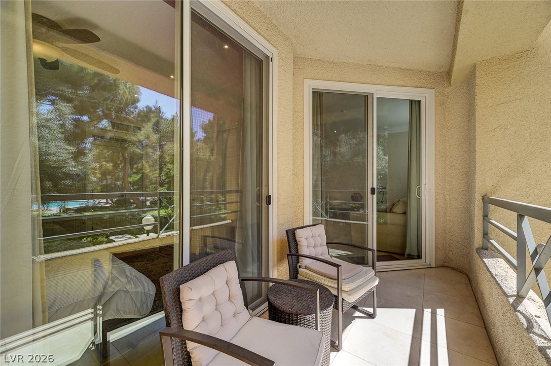 230 East Flamingo Road, Unit 106 Las Vegas, NV 89169 - Photo 23 of 66 An inviting balcony space overlooks lush greenery and a tranquil pool, perfect for outdoor enjoyment.