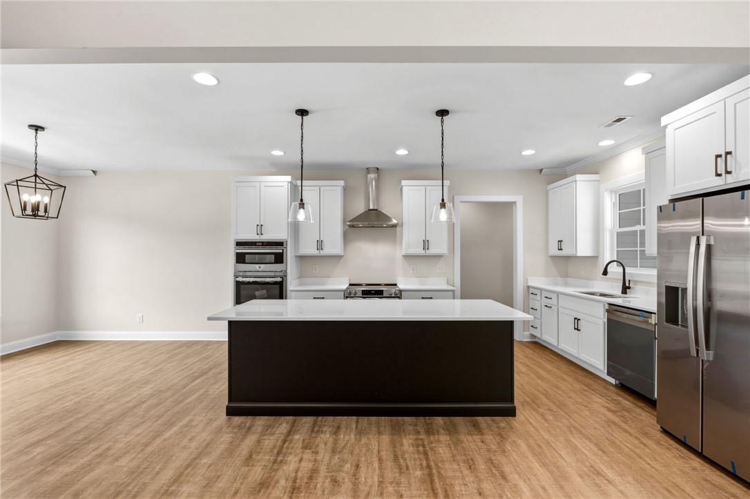 1735 Maw Bridge Road Central, SC 29630 - Photo 10 of 38 This modern kitchen features a spacious island and sleek, integrated appliances, creating an inviting culinary space.