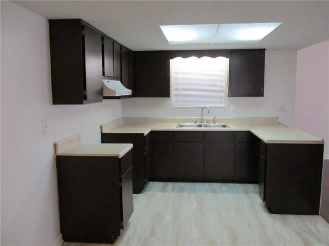 a kitchen with a sink and a wooden cabinets