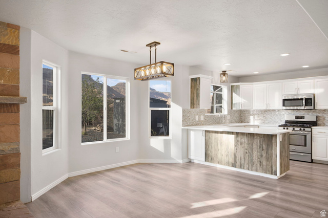 1440 West 100 South Virgin, UT 84779 - Photo 11 of 45 Open-concept living space featuring wood-finish flooring, a stone-faced fireplace, and expansive windows