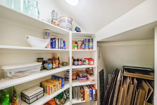 a room with furniture a baby crib and a book shelf