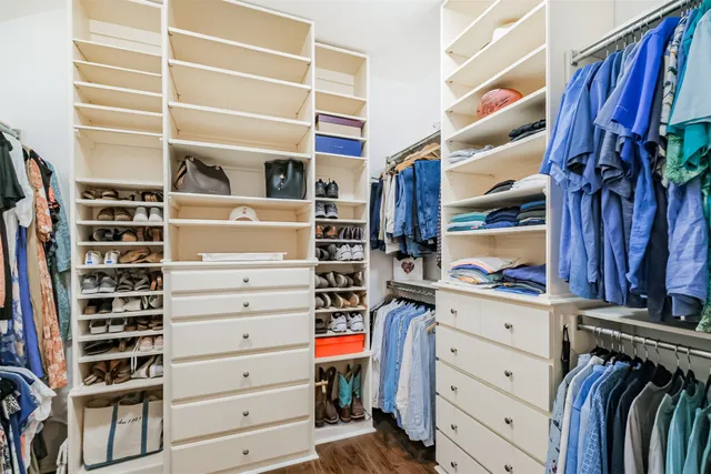 a view of walk in closet with clothes and shoes