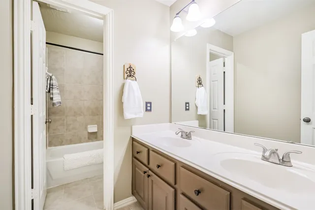a bathroom with a shower sink vanity and mirror