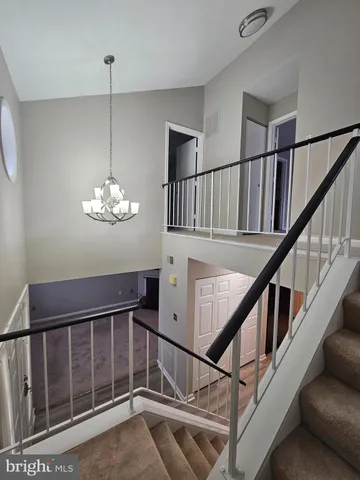 a view of road with card parked on side and retail shops