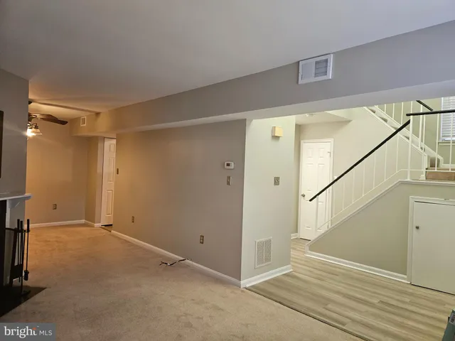 an empty room with a window and ceiling fan