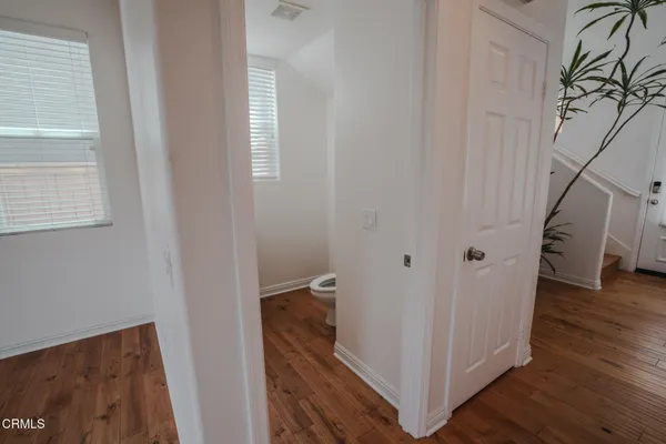 a view of a hallway with wooden floor and staircase