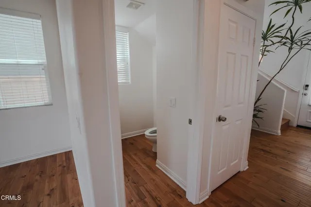 a view of a hallway with wooden floor and staircase