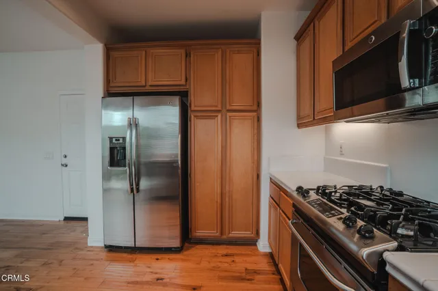 a kitchen with stainless steel appliances granite countertop a refrigerator stove and microwave