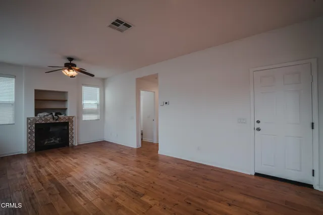 a view of a kitchen with a sink a ceiling fan and wooden floor