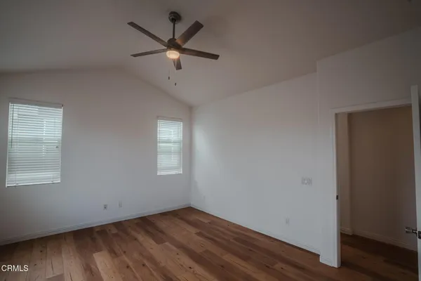 a view of a big room with wooden floor and windows